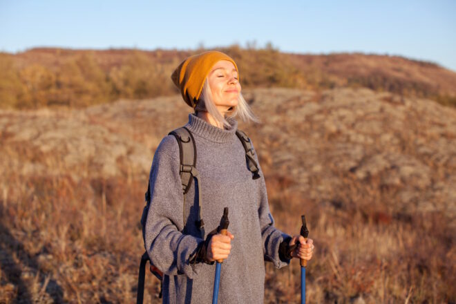 Middle Aged Woman Hiking And Going Camping In Autumn Forest